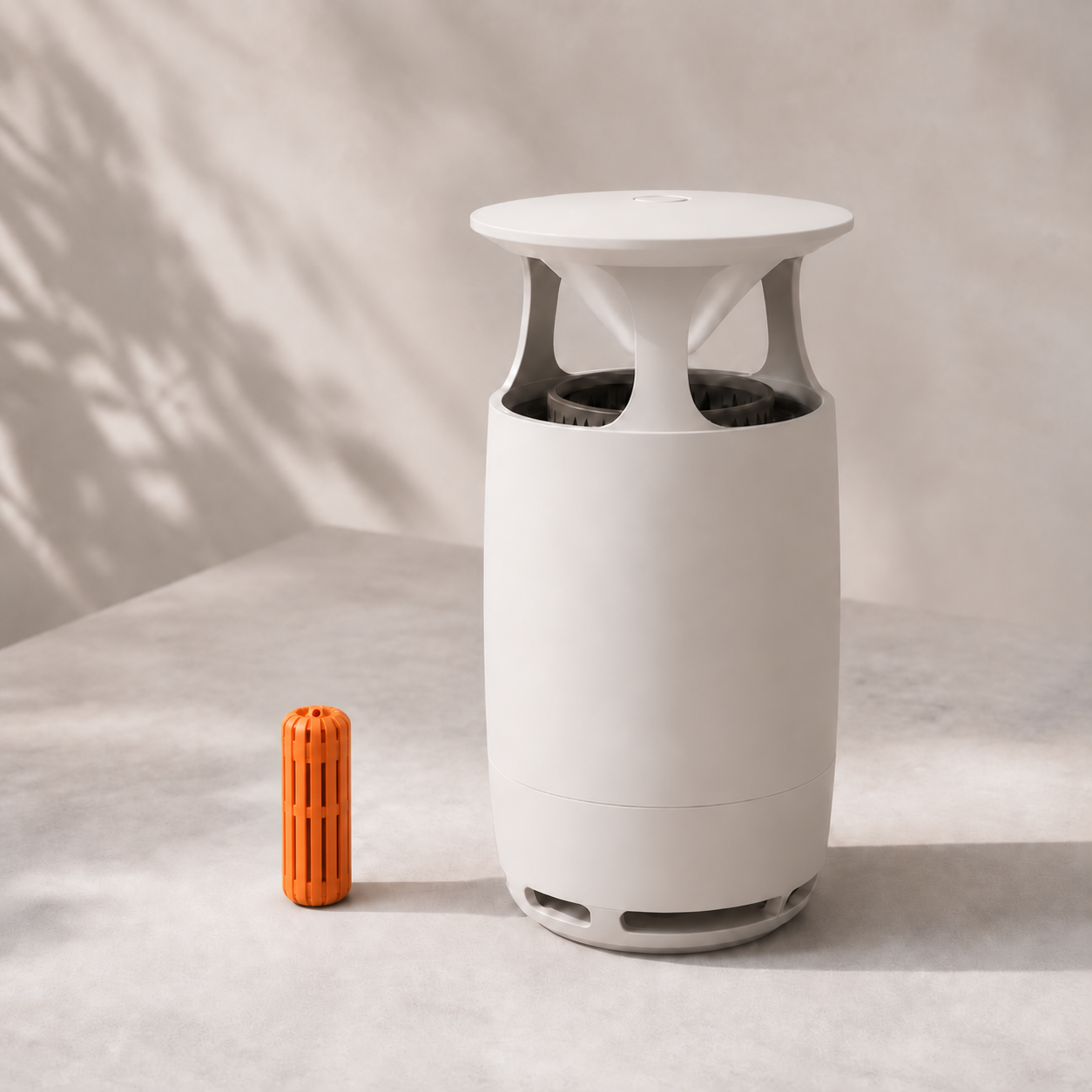 Orange ribbed pheromone dispenser beside a refined white trap